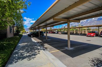 A parking lot with cars parked under a covered area.